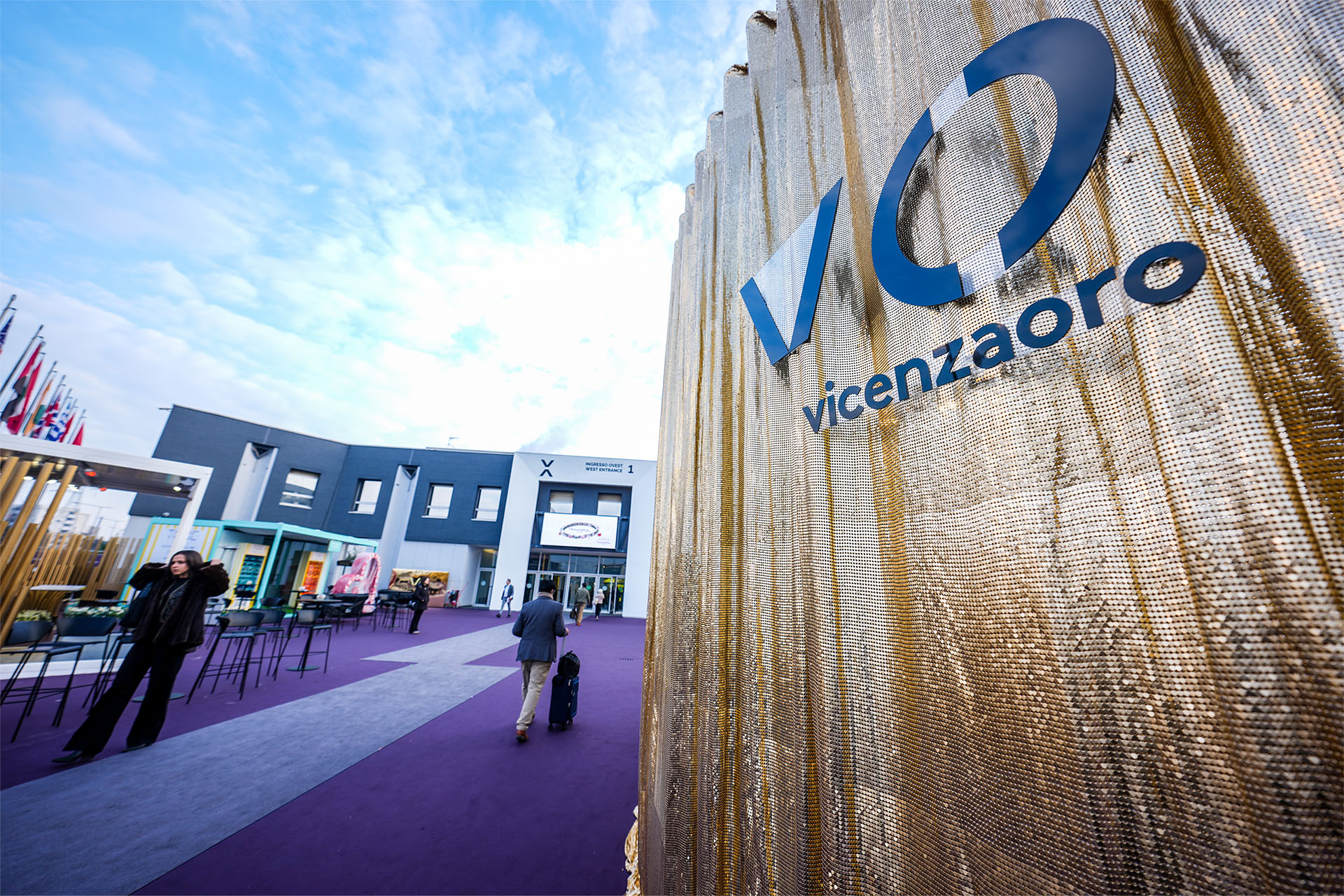 Tenda dorata a maglia metallica con logo Vicenzaoro blu all'ingresso fiera gennaio 2026