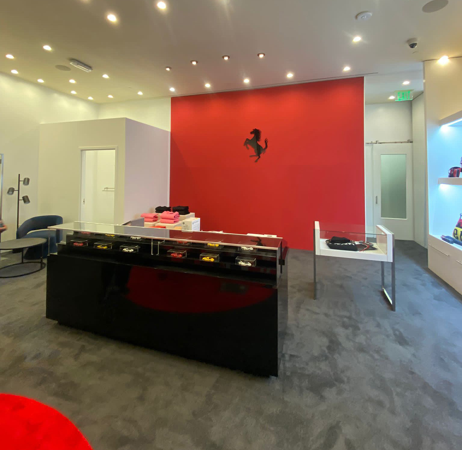 Interno Ferrari Boutique con parete rossa cavallino rampante e teche modellini auto