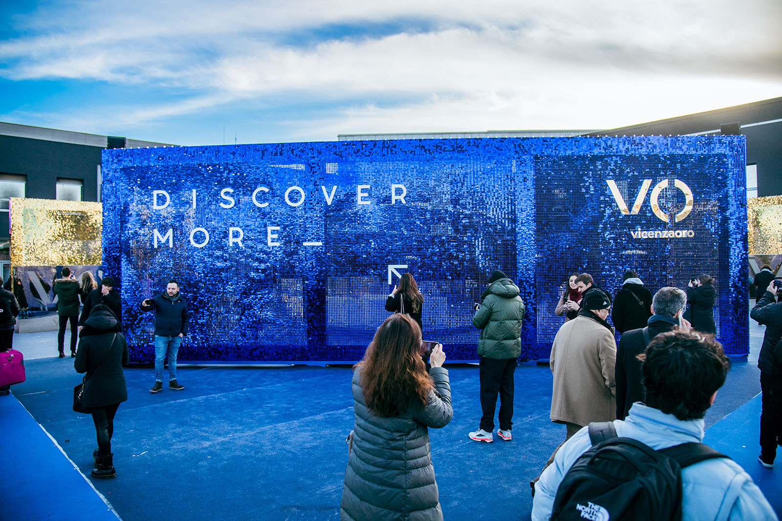 Parete scenografica blu Discover More Vicenzaoro gennaio 2023 con visitatori in fiera
