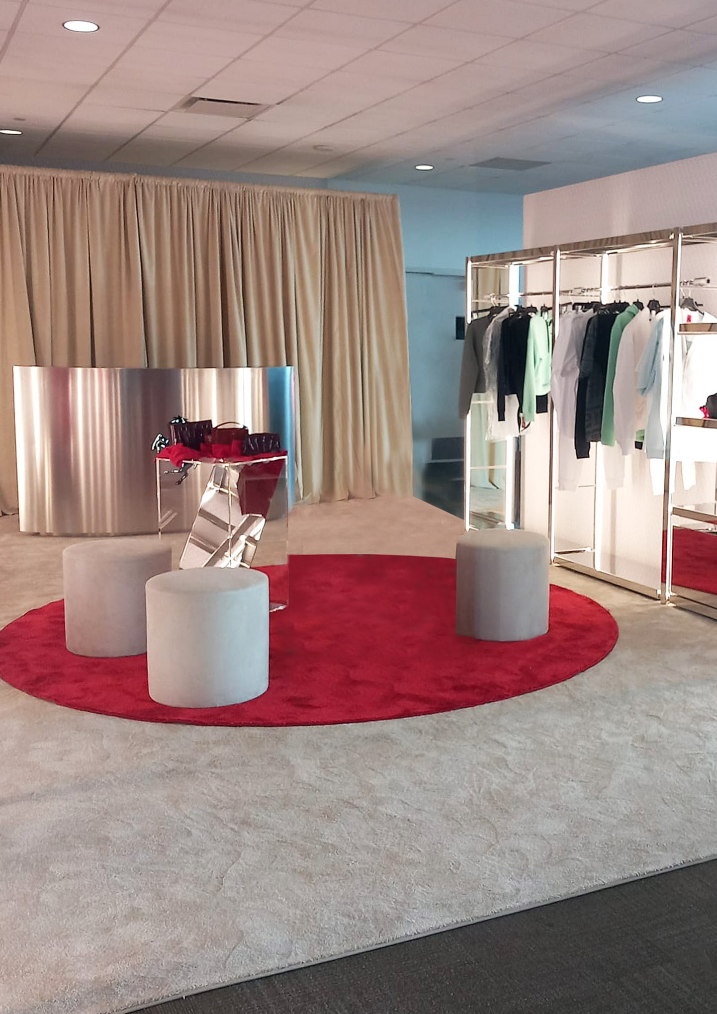 Lounge Ferrari Challenge COTA 2024 con tappeto rotondo rosso pouf grigi e rack abbigliamento