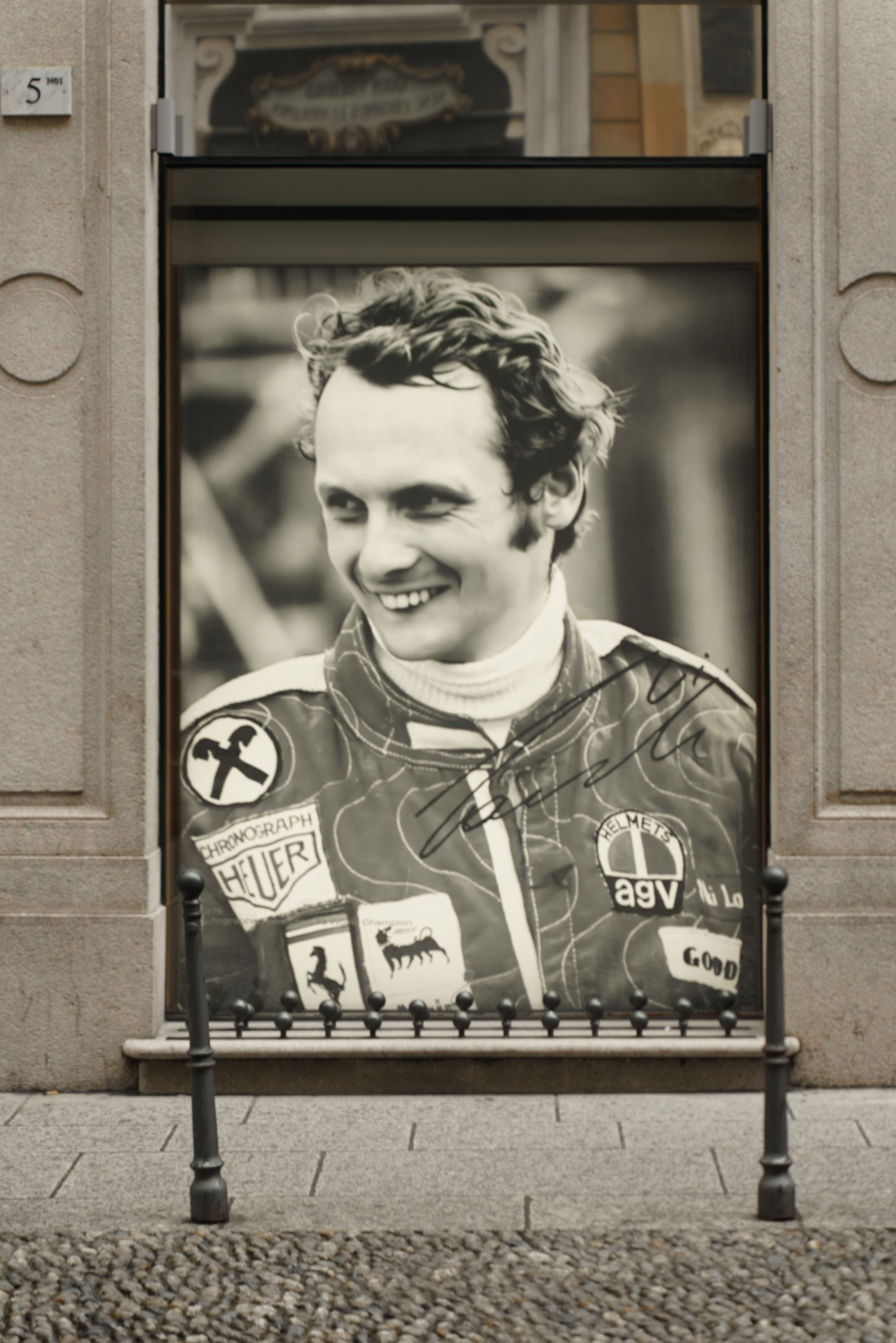 Vetrina Ferrari pop-in Milano con stampa vintage di Niki Lauda autografata in tuta da pilota