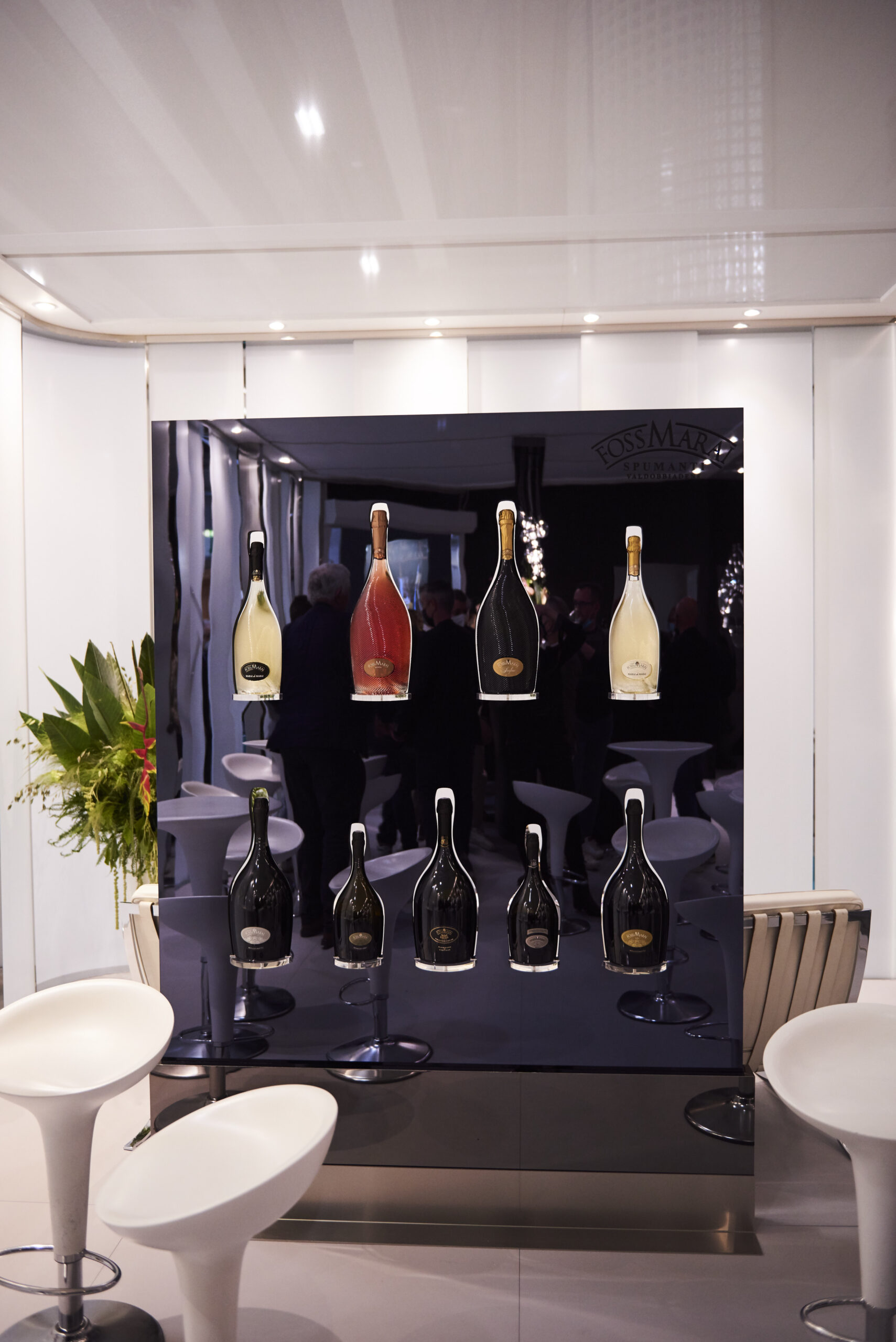 Vetrina Foss Marai Vinitaly con bottiglie spumante sospese su pannello scuro lucido