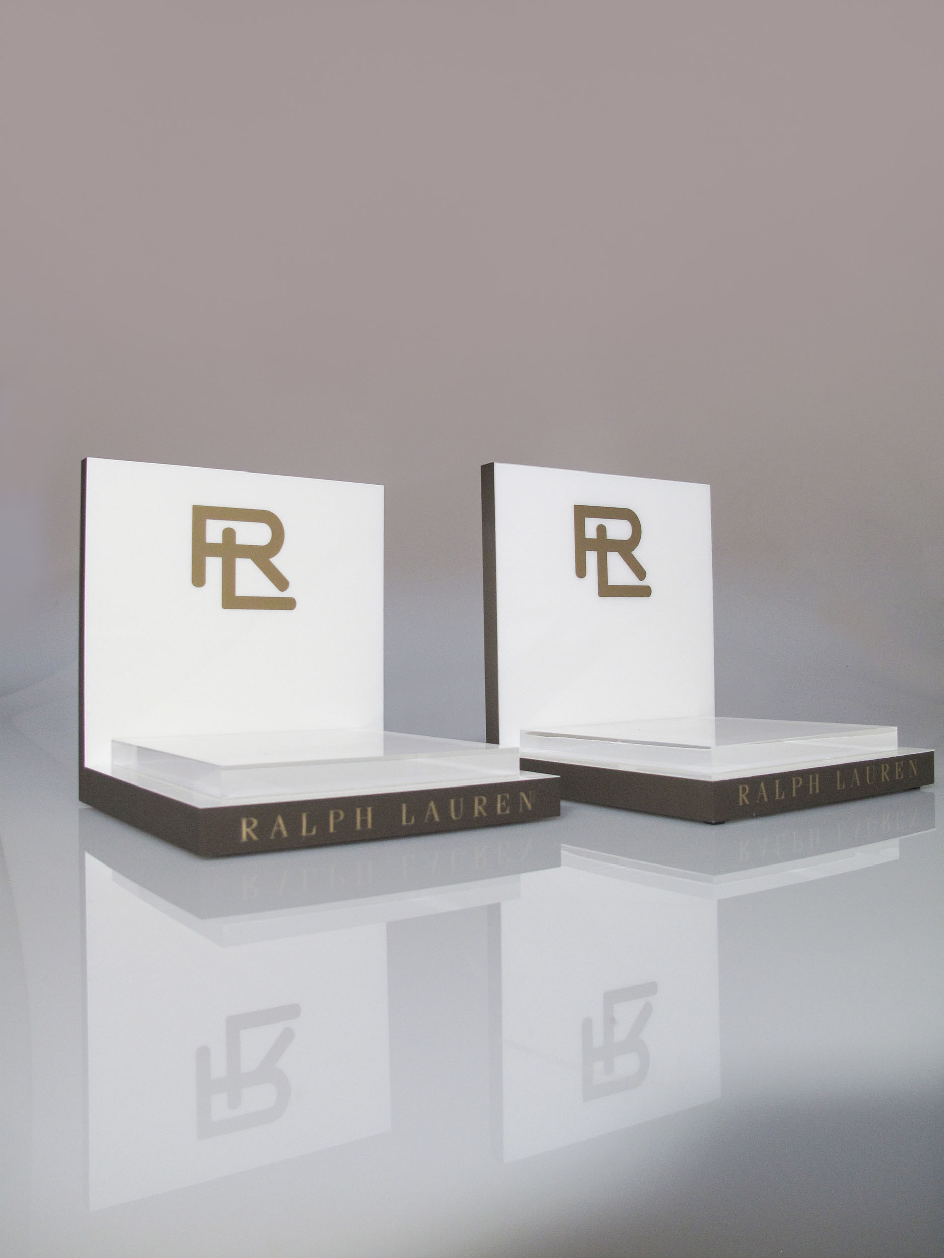 Espositori bookend Ralph Lauren in plexiglass bianco con monogramma RL dorato e base scura logata